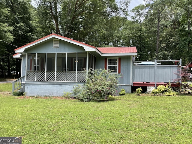 501 Lakeshore Dr, Monticello, GA 31064 - view of front of property with a sunroom, a front yard, a wooden deck, and metal roof