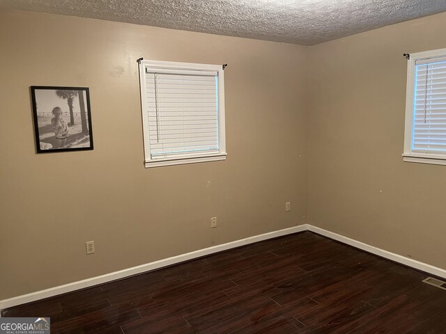 501 Lakeshore Dr, Monticello, GA 31064 - empty room with dark wood-style floors, a textured ceiling, and baseboards