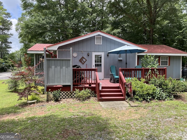 501 Lakeshore Dr, Monticello, GA 31064 - view of front of property featuring a front yard, a deck, and metal roof