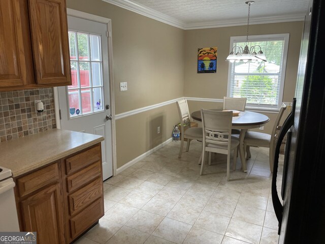 501 Lakeshore Dr, Monticello, GA 31064 - dining room featuring plenty of natural light, crown molding, light tile patterned flooring, baseboards, and a chandelier