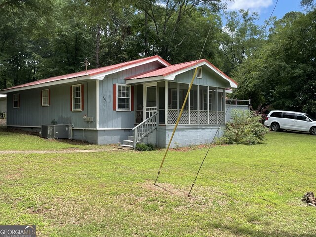 501 Lakeshore Dr, Monticello, GA 31064 - manufactured / mobile home with metal roof, a sunroom, crawl space, and a front lawn