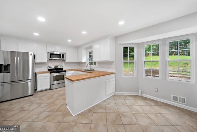 4197 Chadds Xing, Marietta, GA 30062 - kitchen featuring appliances with stainless steel finishes, a sink, a peninsula, butcher block counters, and white cabinets