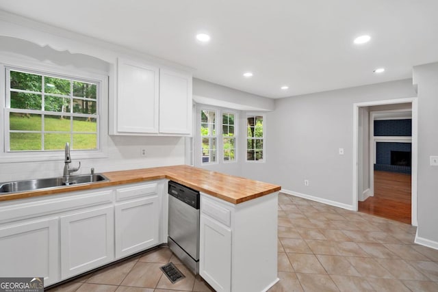 4197 Chadds Xing, Marietta, GA 30062 - kitchen featuring stainless steel dishwasher, butcher block countertops, a sink, a peninsula, and light tile patterned flooring