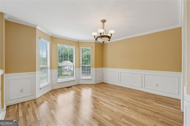12290 Greenmont Walk, Alpharetta, GA 30009 - unfurnished dining area featuring a chandelier, ornamental molding, a wainscoted wall, and light wood finished floors