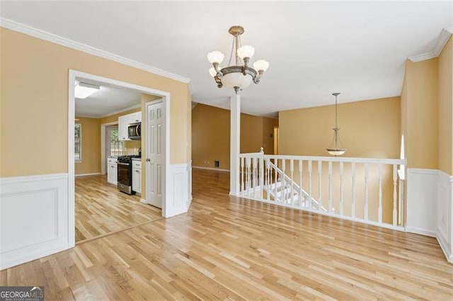 12290 Greenmont Walk, Alpharetta, GA 30009 - spare room featuring light wood finished floors, wainscoting, a chandelier, crown molding, and a decorative wall