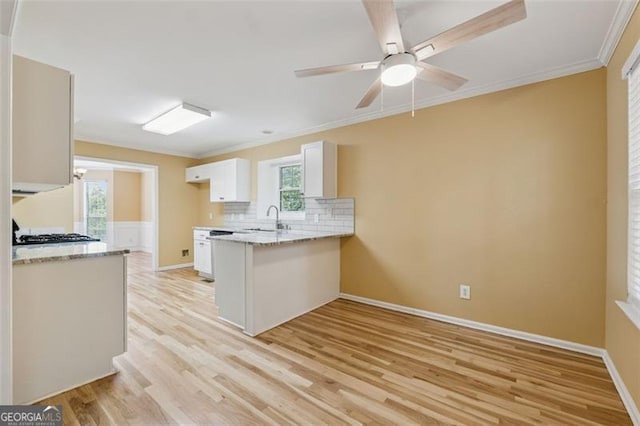 12290 Greenmont Walk, Alpharetta, GA 30009 - kitchen with a peninsula, light wood-style flooring, white cabinetry, ornamental molding, and backsplash