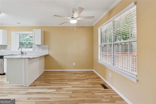 12290 Greenmont Walk, Alpharetta, GA 30009 - kitchen featuring crown molding, white cabinetry, tasteful backsplash, light wood-style floors, and baseboards