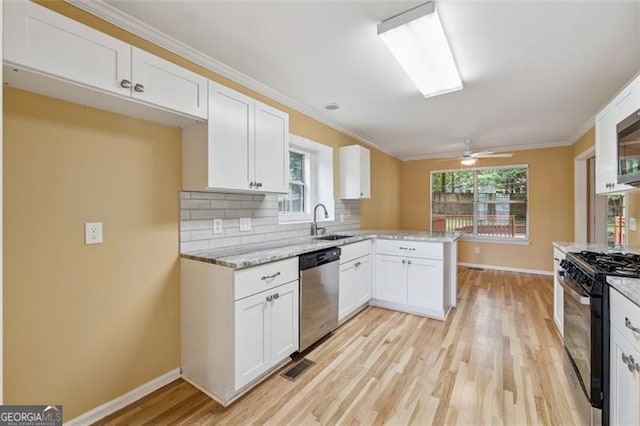 12290 Greenmont Walk, Alpharetta, GA 30009 - kitchen with dishwasher, black gas range, a sink, light wood-style flooring, and ornamental molding