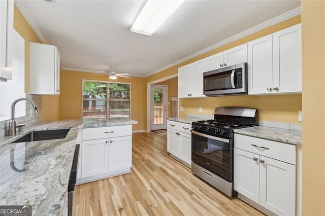 12290 Greenmont Walk, Alpharetta, GA 30009 - kitchen featuring appliances with stainless steel finishes, a sink, white cabinetry, light wood-type flooring, and a peninsula
