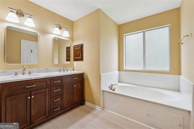 12290 Greenmont Walk, Alpharetta, GA 30009 - bathroom featuring double vanity, wood finished floors, a bath, and baseboards