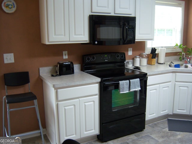 225 Long Creek Dr, Covington, GA 30016 - kitchen with black appliances, white cabinets, light countertops, and a sink