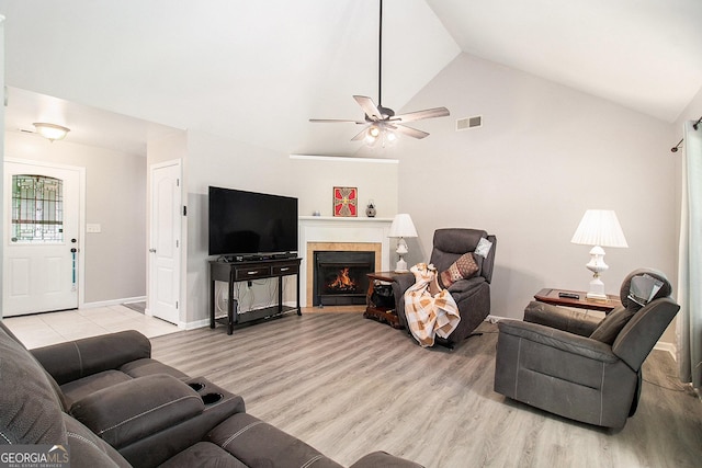 325 Leonard Rd, Lagrange, GA 30241 - living area featuring vaulted ceiling, ceiling fan, light wood finished floors, a lit fireplace, and baseboards