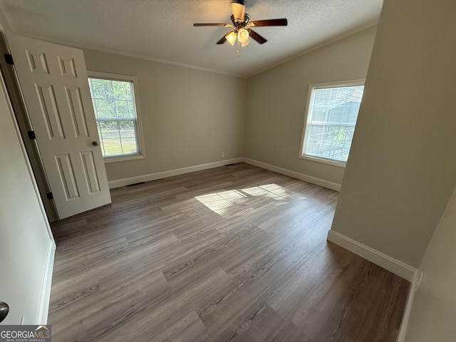 179 Creek Ridge Rd, Claxton, GA 30417 - unfurnished room with healthy amount of natural light, lofted ceiling, a textured ceiling, a ceiling fan, and wood finished floors