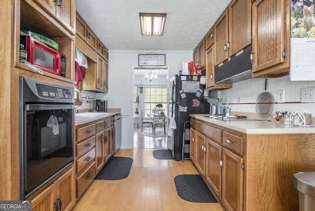 2969 White Rd NE, Conyers, GA 30012 - kitchen featuring black appliances, brown cabinets, light countertops, extractor fan, and tasteful backsplash