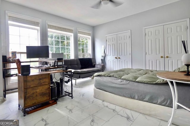5996 Eagle Tiff Ln, Sugar Hill, GA 30518 - bedroom with marble look tiles, multiple closets, a desk, and a ceiling fan