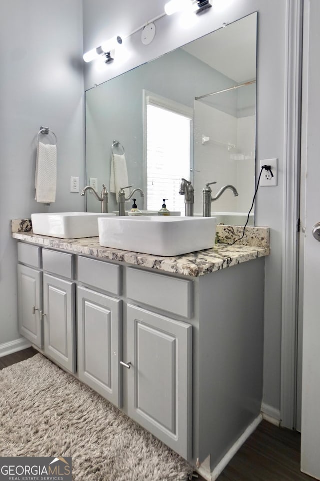 5996 Eagle Tiff Ln, Sugar Hill, GA 30518 - bathroom featuring wood finished floors, double vanity, and a shower