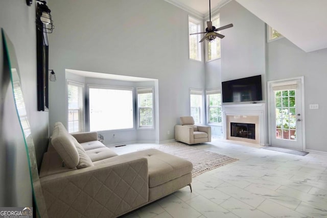 5996 Eagle Tiff Ln, Sugar Hill, GA 30518 - living room featuring light marble finish floors, a fireplace, a ceiling fan, and a high ceiling