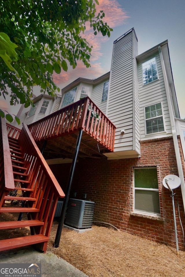 5996 Eagle Tiff Ln, Sugar Hill, GA 30518 - rear view of house featuring stairway, a deck, a chimney, and brick siding