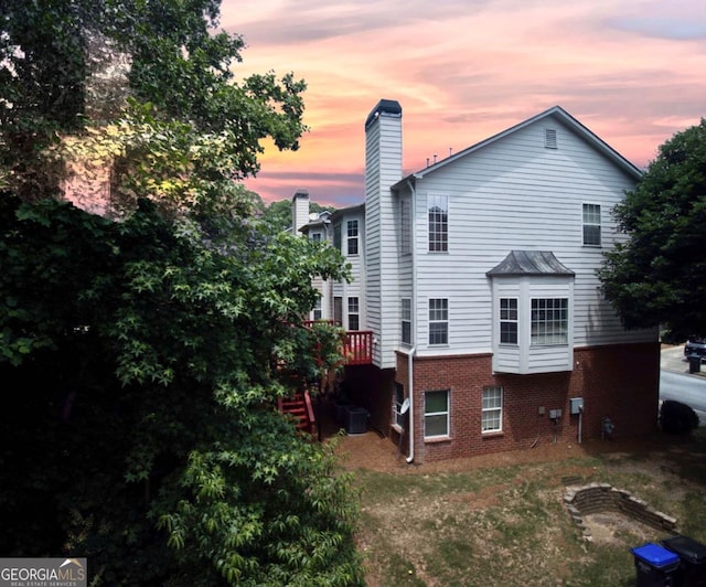 5996 Eagle Tiff Ln, Sugar Hill, GA 30518 - back of house at dusk featuring brick siding and a chimney