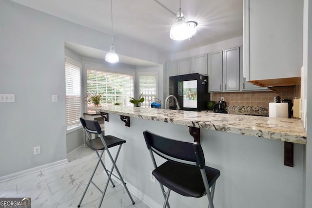 5996 Eagle Tiff Ln, Sugar Hill, GA 30518 - kitchen with refrigerator, a peninsula, tasteful backsplash, and a kitchen bar