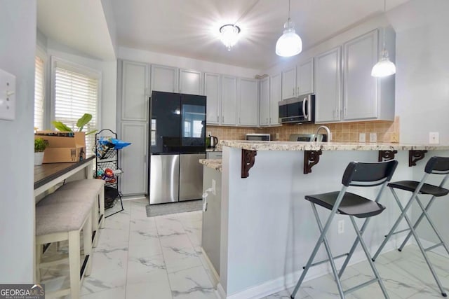 5996 Eagle Tiff Ln, Sugar Hill, GA 30518 - kitchen with stainless steel appliances, light marble finish flooring, a peninsula, a breakfast bar, and backsplash