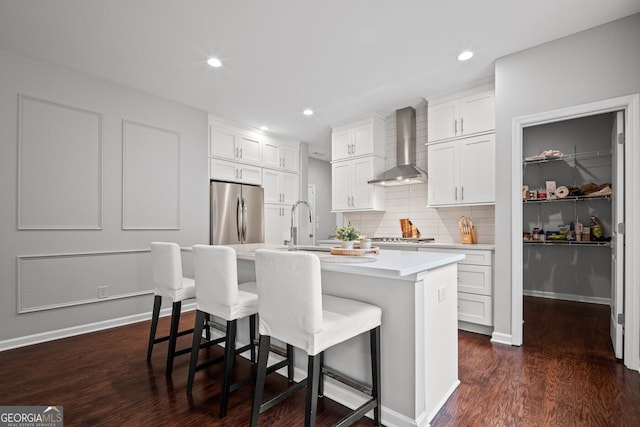 149 Archie Way, Woodstock, GA 30188 - kitchen with wall chimney exhaust hood, appliances with stainless steel finishes, a kitchen bar, a center island with sink, and recessed lighting