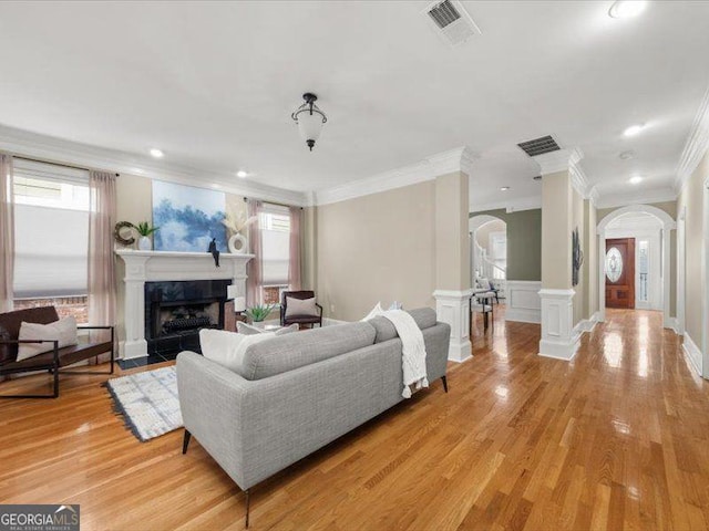 121 Fulton Way SE, Atlanta, GA 30312 - living room featuring arched walkways, ornamental molding, a fireplace, plenty of natural light, and light wood-type flooring