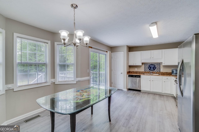 236 Fairview Dr, Dallas, GA 30157 - kitchen with stainless steel appliances, white cabinetry, light wood-style floors, and a chandelier