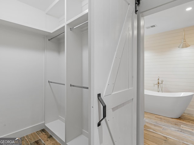 3905 Pointer Rd, Loganville, GA 30052 - full bathroom featuring a freestanding bath, wood finished floors, and a closet
