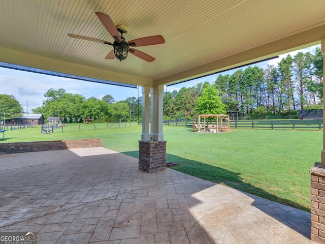 3905 Pointer Rd, Loganville, GA 30052 - fenced backyard with a patio, a playground, ceiling fan, and view of wooded area