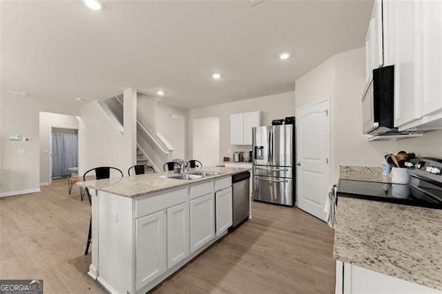 352 Walnut Grove Way, Pendergrass, GA 30567 - kitchen featuring stainless steel appliances, a breakfast bar area, light wood-type flooring, a kitchen island with sink, and recessed lighting
