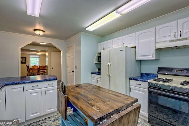 4618 Jones Gap Rd, Hiawassee, GA 30546 - kitchen featuring black range with gas stovetop, under cabinet range hood, freestanding refrigerator, arched walkways, and white cabinets