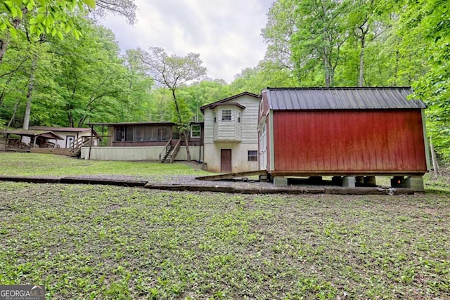 4618 Jones Gap Rd, Hiawassee, GA 30546 - view of outbuilding with stairway, a sunroom, and view of wooded area