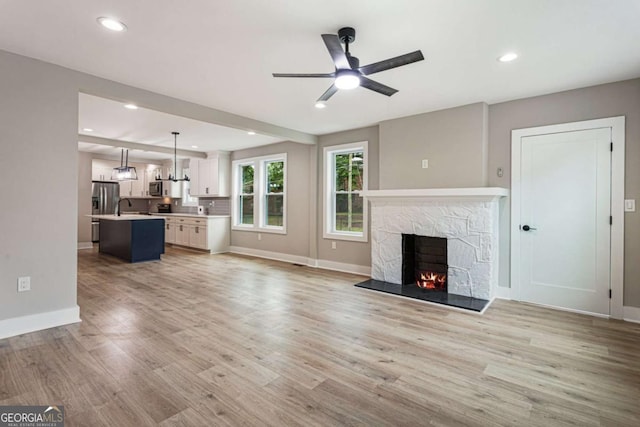 1283 Beecher St SW, Atlanta, GA 30310 - unfurnished living room with ceiling fan, a stone fireplace, light wood-style flooring, and recessed lighting