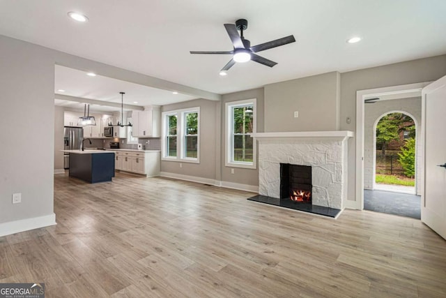 1283 Beecher St SW, Atlanta, GA 30310 - unfurnished living room with ceiling fan, a fireplace, light wood-style flooring, plenty of natural light, and recessed lighting