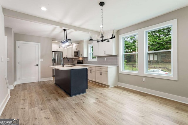 1283 Beecher St SW, Atlanta, GA 30310 - kitchen featuring stainless steel appliances, light countertops, light wood-style flooring, tasteful backsplash, and white cabinetry