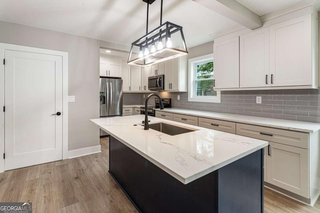 1283 Beecher St SW, Atlanta, GA 30310 - kitchen with stainless steel appliances, light wood-type flooring, tasteful backsplash, a kitchen island with sink, and light stone countertops