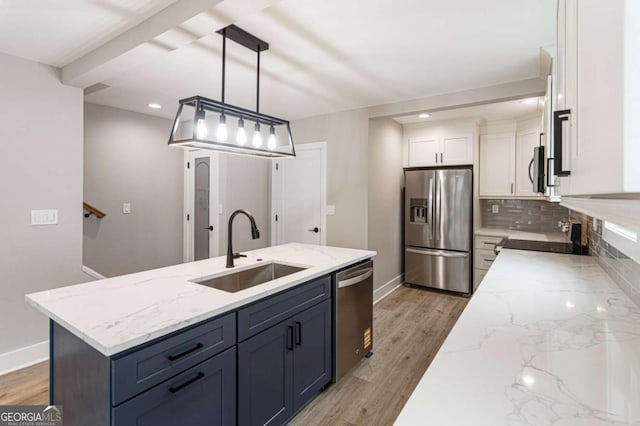 1283 Beecher St SW, Atlanta, GA 30310 - kitchen with appliances with stainless steel finishes, white cabinets, decorative backsplash, light wood-style flooring, and hanging light fixtures