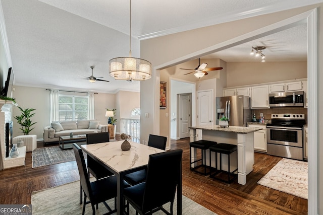 1087 Berkley Dr SE, Smyrna, GA 30082 - dining area featuring a ceiling fan, dark wood-style flooring, a chandelier, ornamental molding, and lofted ceiling
