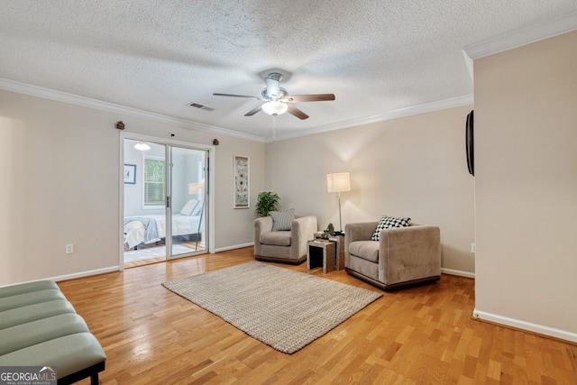 1087 Berkley Dr SE, Smyrna, GA 30082 - living area featuring ceiling fan, ornamental molding, light wood-type flooring, baseboards, and a textured ceiling