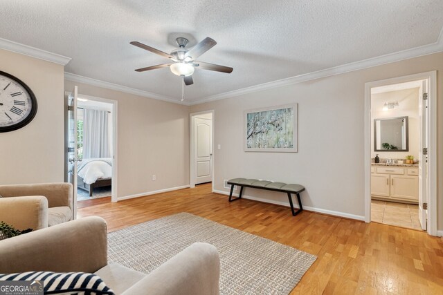 1087 Berkley Dr SE, Smyrna, GA 30082 - living room with light wood-style floors, ceiling fan, crown molding, a textured ceiling, and baseboards