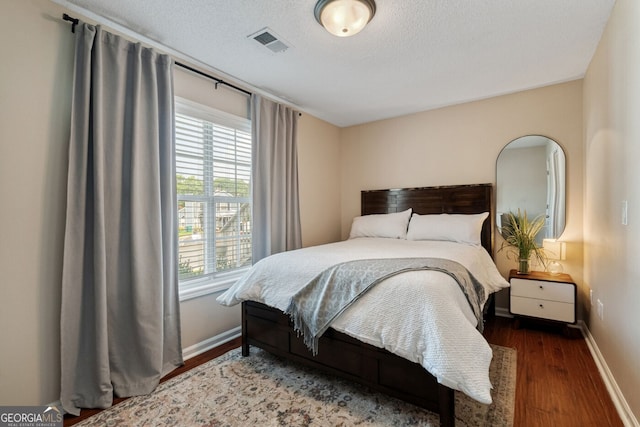 1087 Berkley Dr SE, Smyrna, GA 30082 - bedroom featuring wood finished floors, multiple windows, baseboards, and a textured ceiling