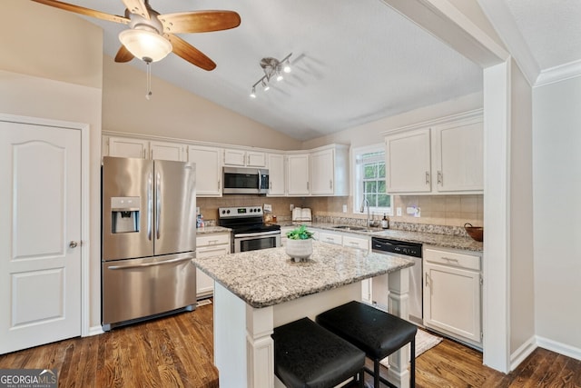 1087 Berkley Dr SE, Smyrna, GA 30082 - kitchen with appliances with stainless steel finishes, white cabinetry, a sink, tasteful backsplash, and vaulted ceiling
