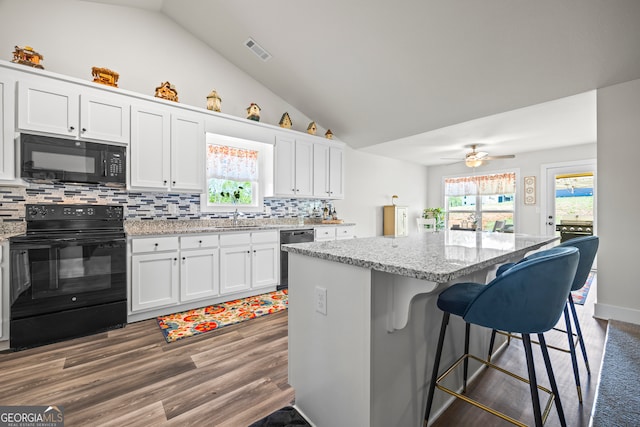 290 Bowers Estates Dr, Hartwell, GA 30643 - kitchen with black appliances, lofted ceiling, a breakfast bar, white cabinets, and a sink