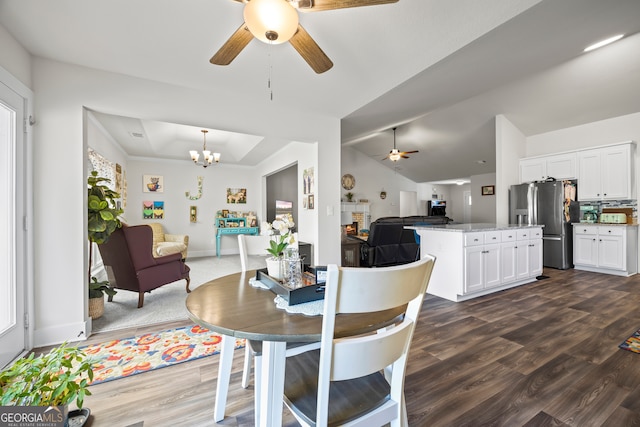 290 Bowers Estates Dr, Hartwell, GA 30643 - dining room featuring ceiling fan, dark wood-type flooring, a chandelier, a tray ceiling, and lofted ceiling
