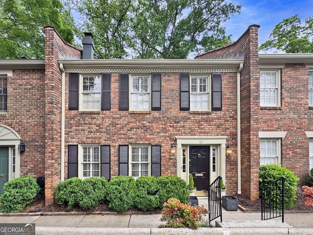 70 Old Ivy Rd NE Unit 57, Atlanta, GA 30342 - view of front of property featuring brick siding, a chimney, and entry steps