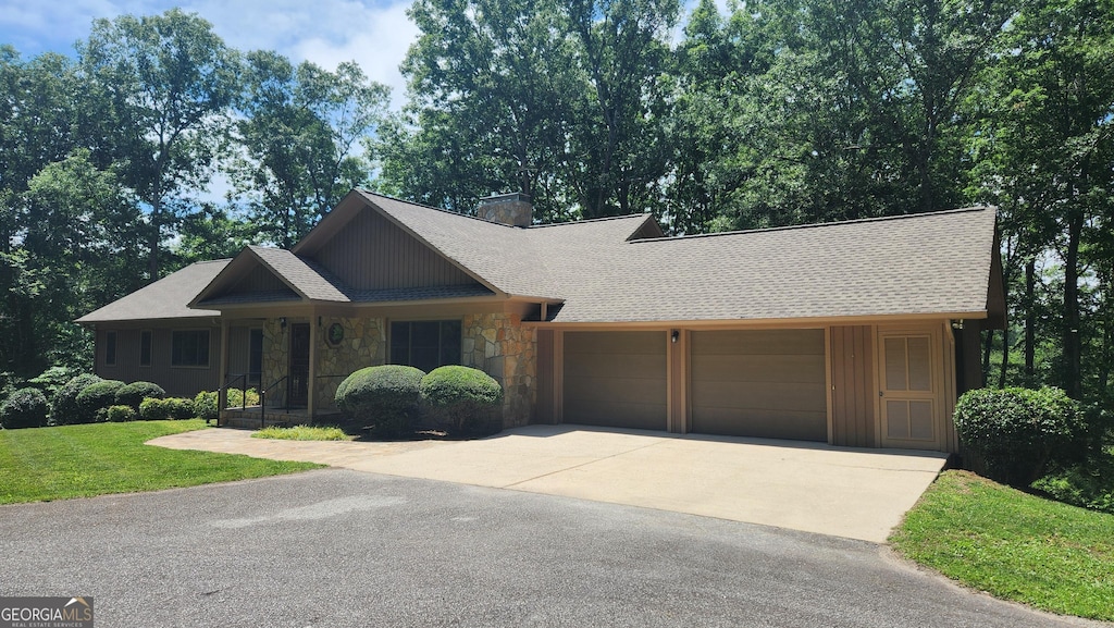 232 Fenwick Wood, Clarkesville, GA 30523 - view of front of house featuring stone siding, a garage, concrete driveway, a chimney, and a front lawn