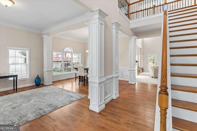 3113 Brians Creek Dr SE, Conyers, GA 30013 - foyer with decorative columns, stairs, light wood-style floors, and crown molding