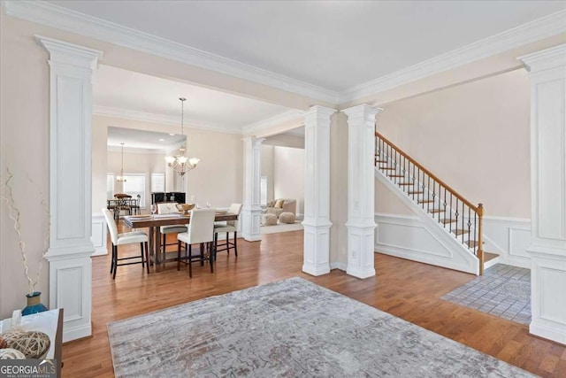 3113 Brians Creek Dr SE, Conyers, GA 30013 - dining room with wood finished floors, decorative columns, ornamental molding, stairway, and a chandelier