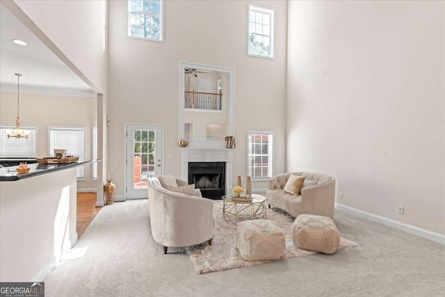 3113 Brians Creek Dr SE, Conyers, GA 30013 - living room featuring a towering ceiling, a fireplace, a chandelier, and carpet